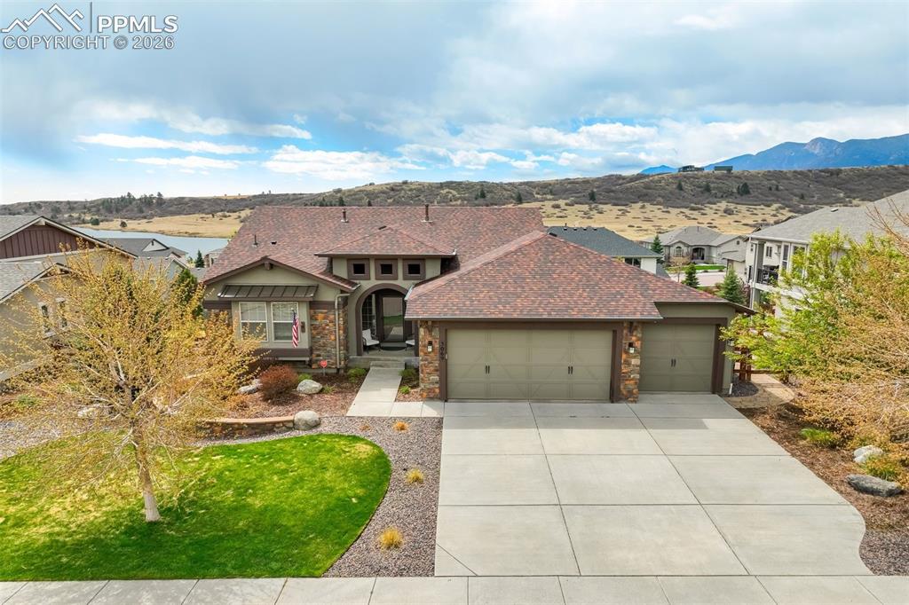 Image 5 of 48: Crafted residence featuring a stone and stucco exterior, a multi-car garage