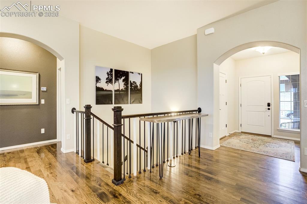 Image 8 of 48: Entryway featuring wood-finish flooring, an arched doorway, and a white fro