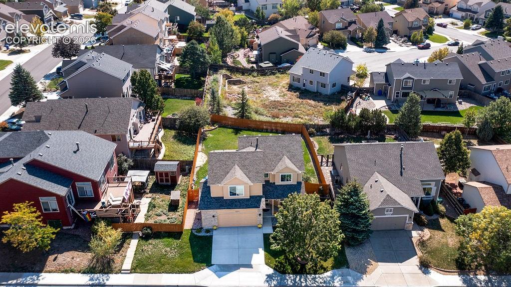 Image 4 of 50: Two-story residence featuring a shingled roof, stucco exterior, attached ga