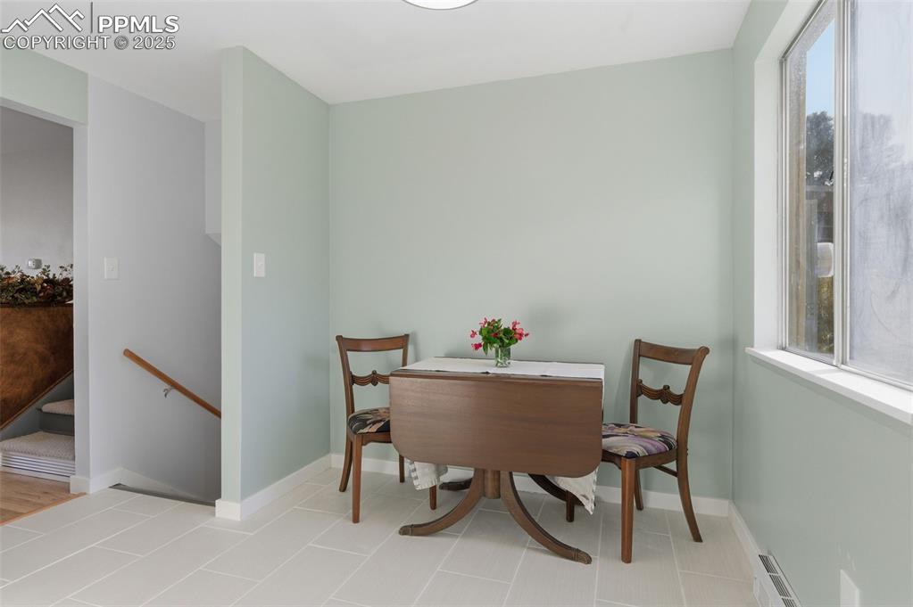 Image 10 of 38: Dining space with baseboards and light ceramic tile patterned flooring