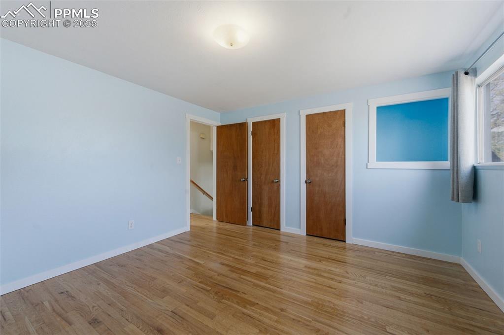 Image 14 of 38: Unfurnished bedroom with multiple closets and light wood-style floors