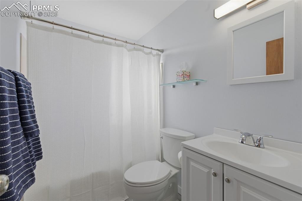 Image 15 of 38: Full bath with vanity, shower / tub combo, and lofted ceiling