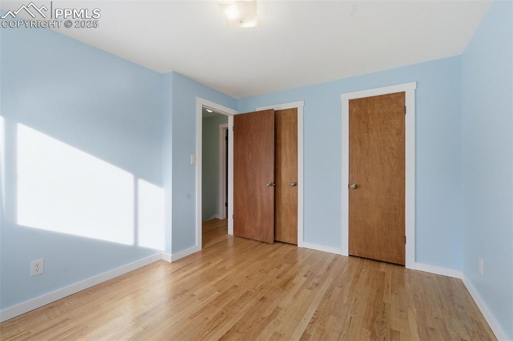 Image 17 of 38: Unfurnished bedroom featuring two closets and wood finished floors