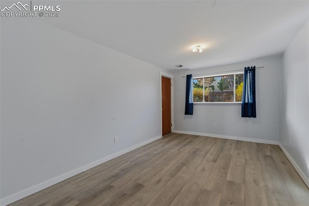 Image 20 of 38: Empty room featuring light wood-type flooring and baseboards