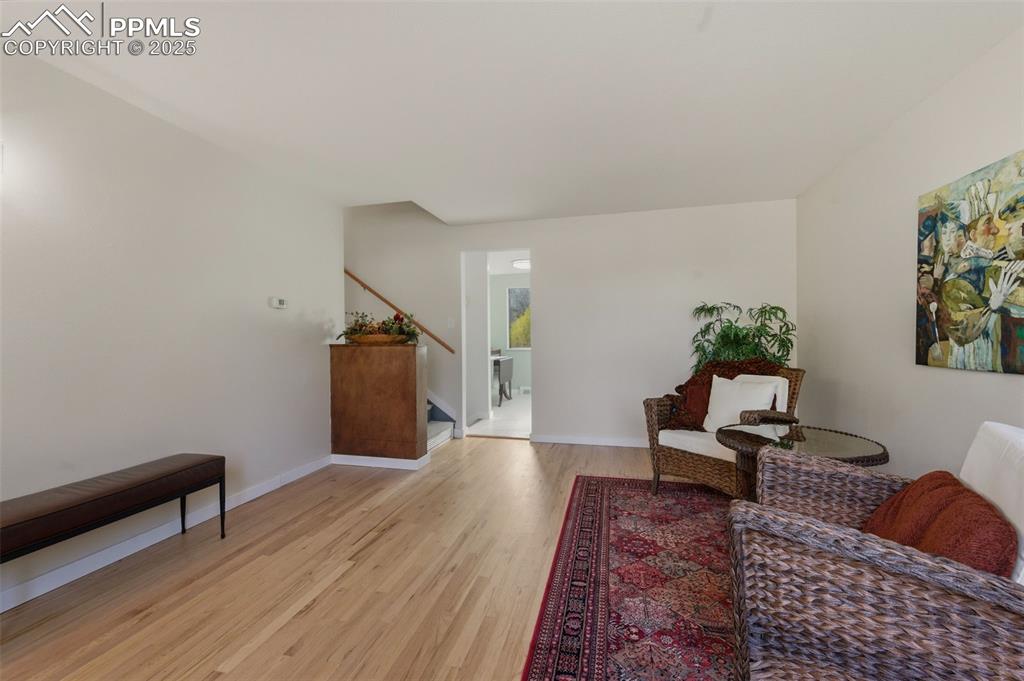 Image 6 of 38: Living area with light wood finished floors and baseboards