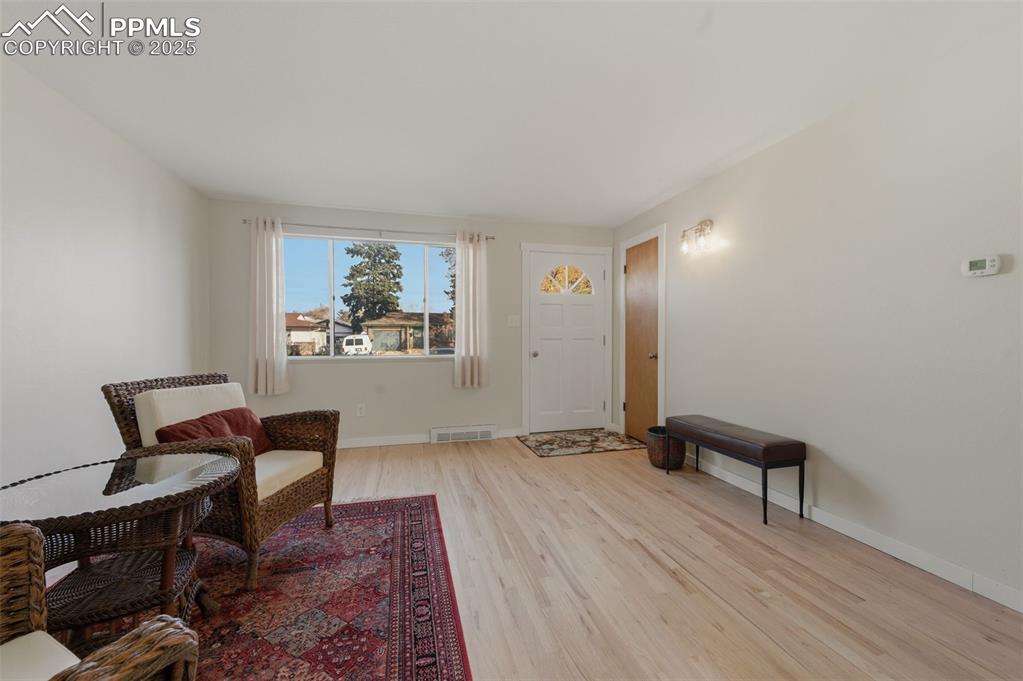 Image 7 of 38: Living room with light wood finished floors and baseboards