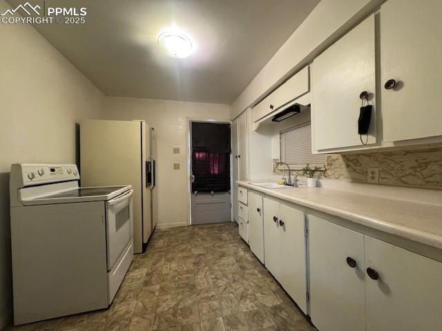 Image 15 of 19: Kitchen featuring electric stove, a sink, white cabinetry, light countertop