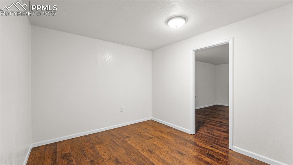 Image 10 of 50: Bonus room featuring dark wood-type flooring and a textured ceiling