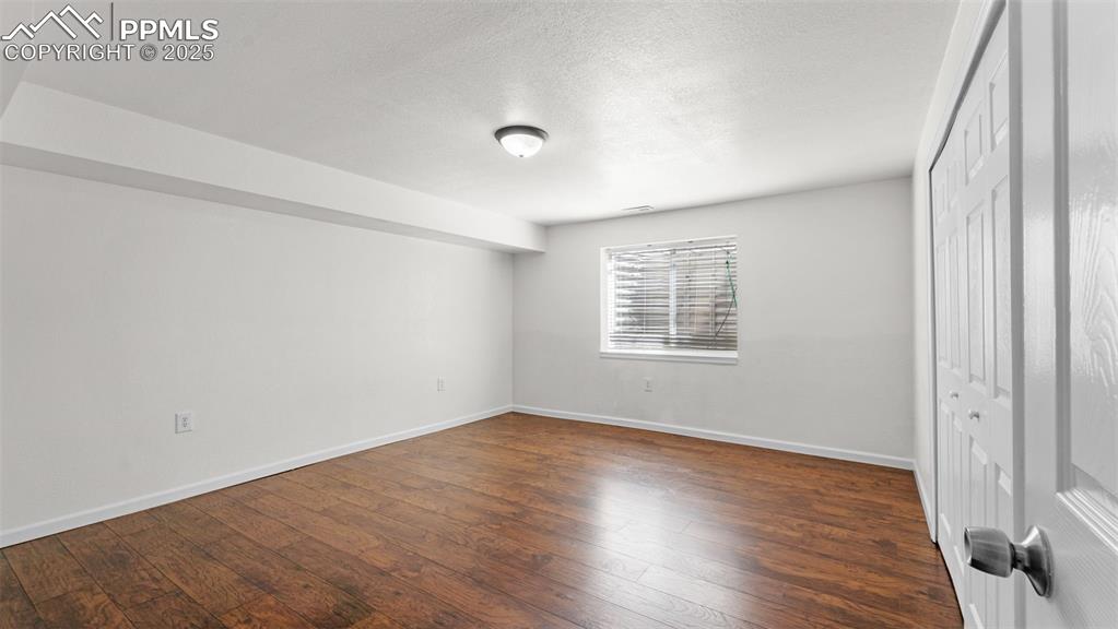 Image 11 of 50: Rec Room with a closet, a textured ceiling, and dark wood finished floors