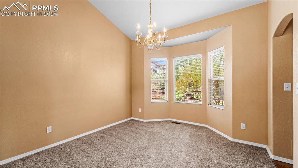 Image 15 of 50: Carpeted Dining room featuring a chandelier and lofted ceiling