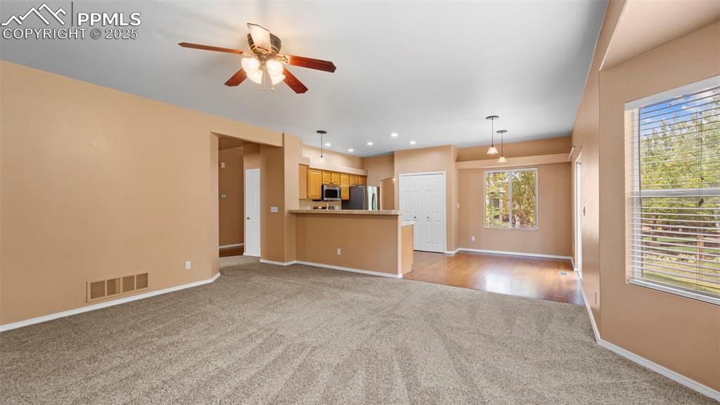 Image 24 of 50: Unfurnished living room with light carpet, ceiling fan, and recessed lighti