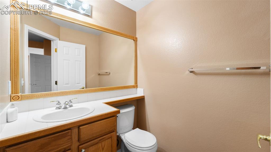 Image 29 of 50: Half bath featuring vanity and a textured wall