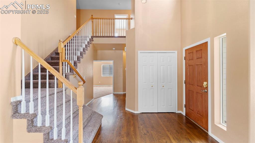 Image 31 of 50: Foyer entrance with a high ceiling, dark wood finished floors, and stairs
