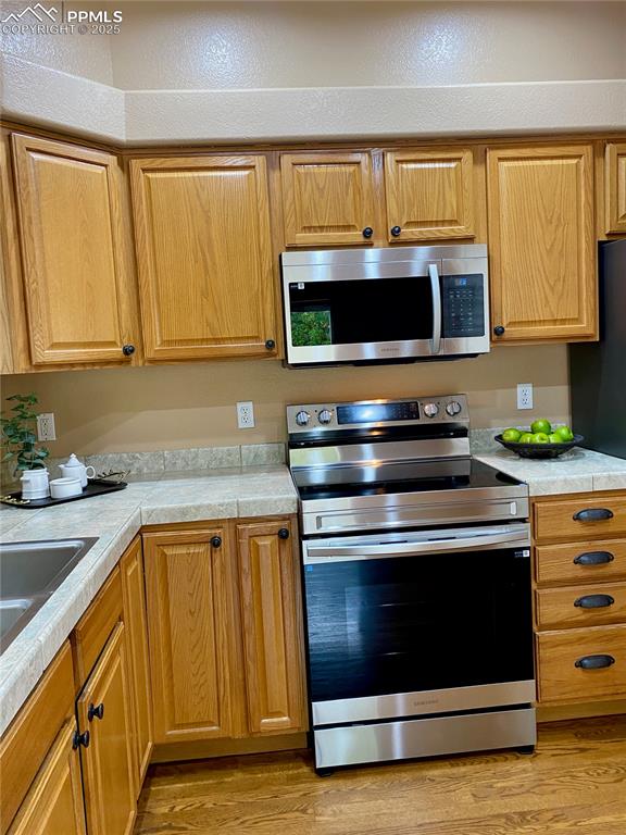 Image 45 of 50: Kitchen featuring stainless steel appliances, light countertops, and light