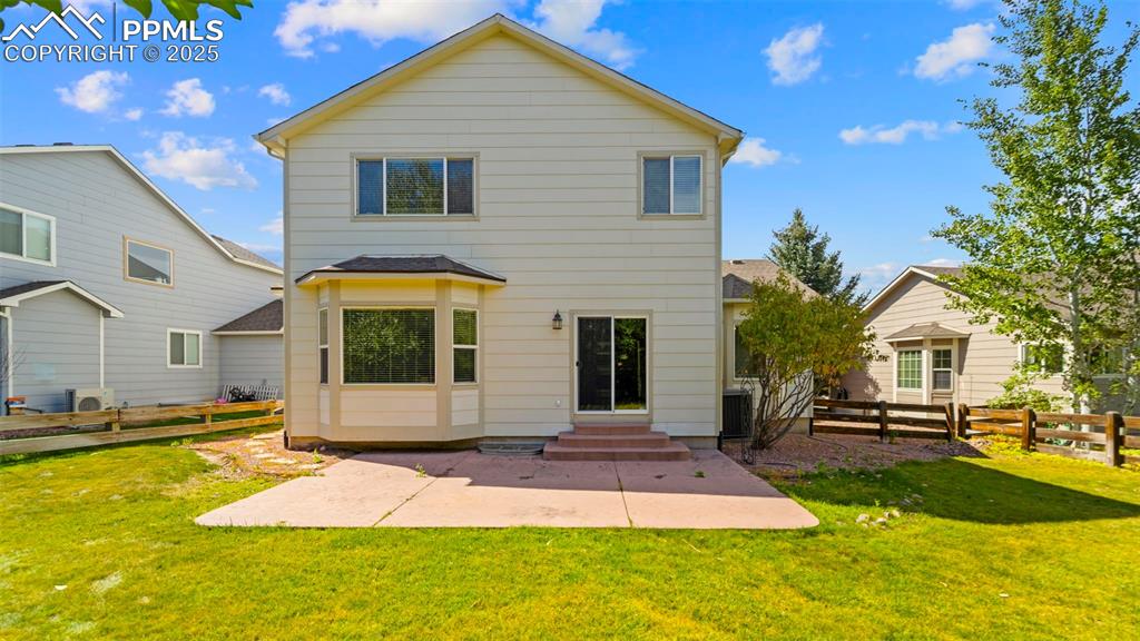 Image 6 of 50: Rear view of house with a patio, a shingled roof, and entry steps