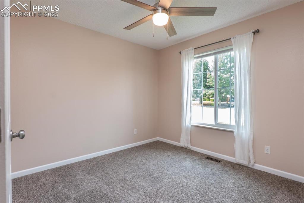 Image 15 of 26: 2nd main level bedroom to include new carpet, closet and ceiling fan.