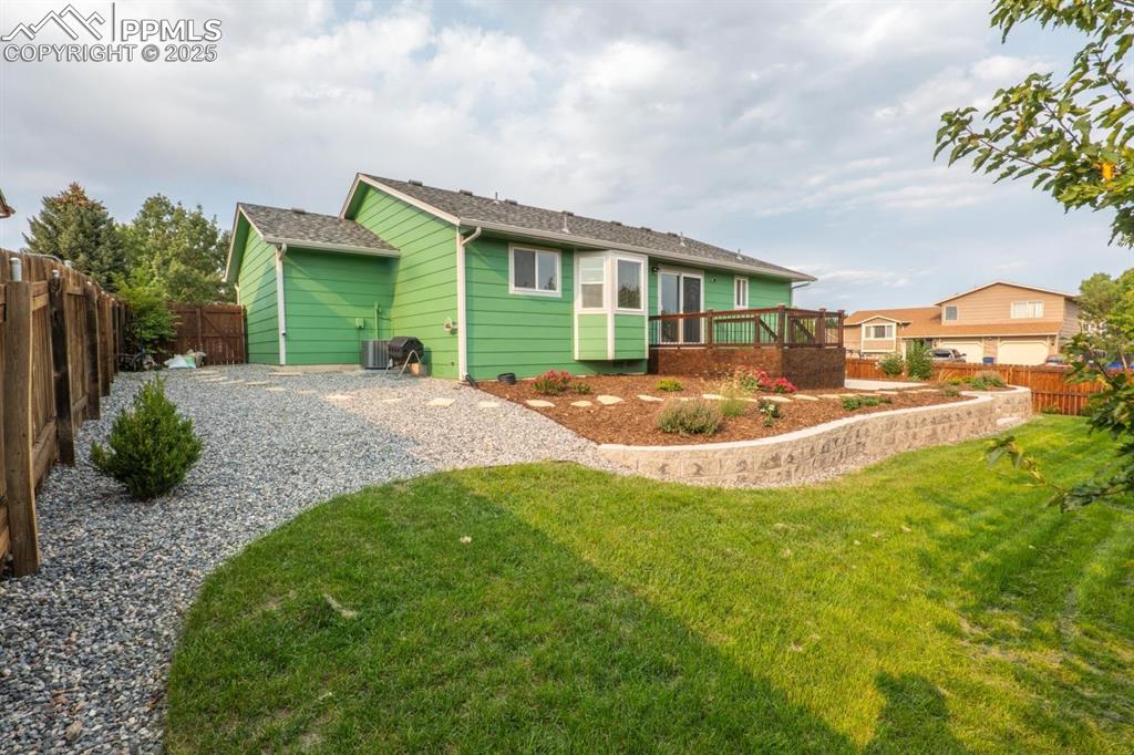 Image 19 of 26: The fully fenced, beautifully landscaped backyard to include a auto sprinkl