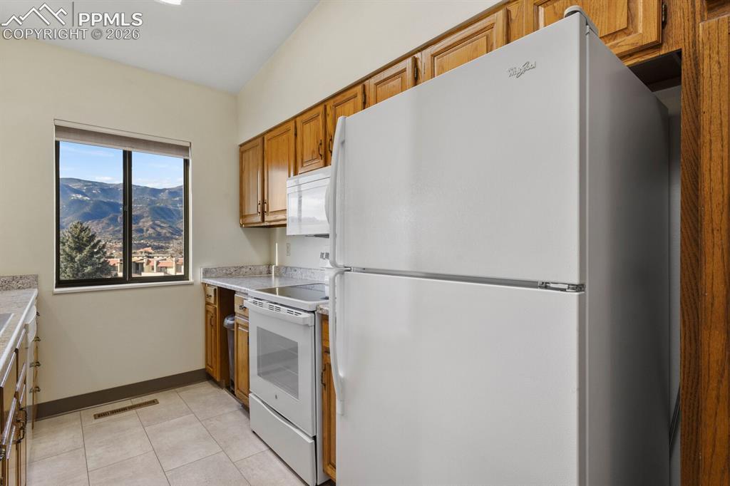 Image 12 of 27: Kitchen featuring a white top-freezer refrigerator, white electric range wi