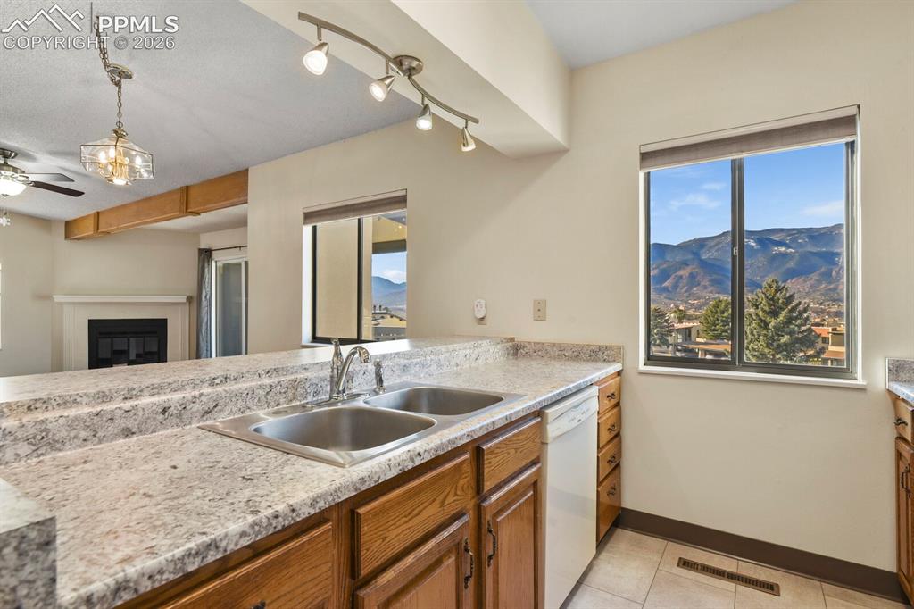 Image 13 of 27: Kitchen featuring a dual basin stainless steel sink, light-toned countertop
