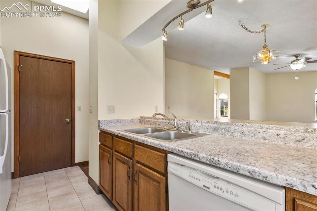 Image 14 of 27: Kitchen featuring wood cabinetry, a dual basin stainless steel sink, and a 