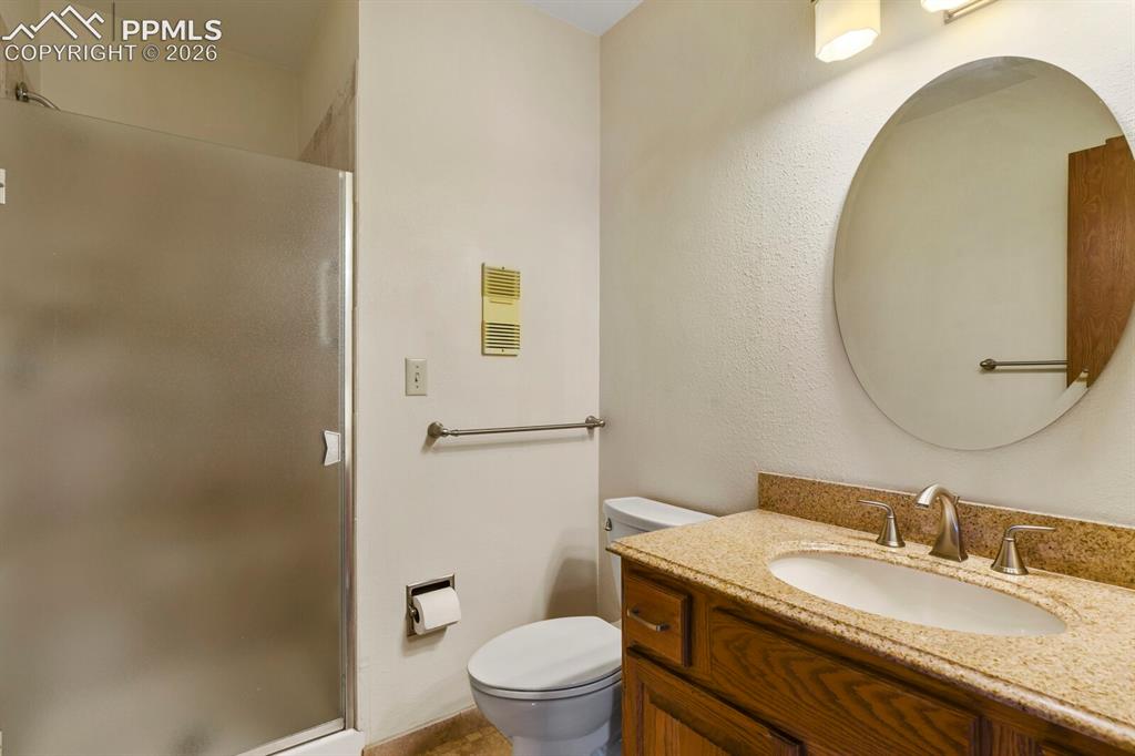 Image 17 of 27: Bathroom featuring a wood vanity with a granite countertop and oval undermo