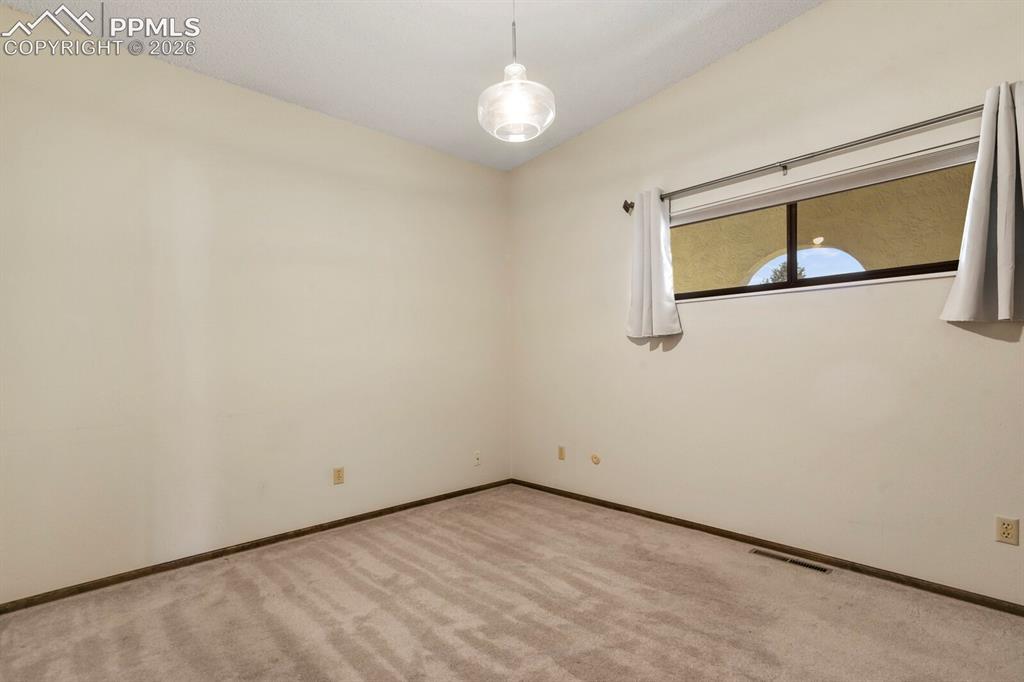 Image 18 of 27: Neutral tone walls with textured ceiling and a modern semi-flush ceiling li