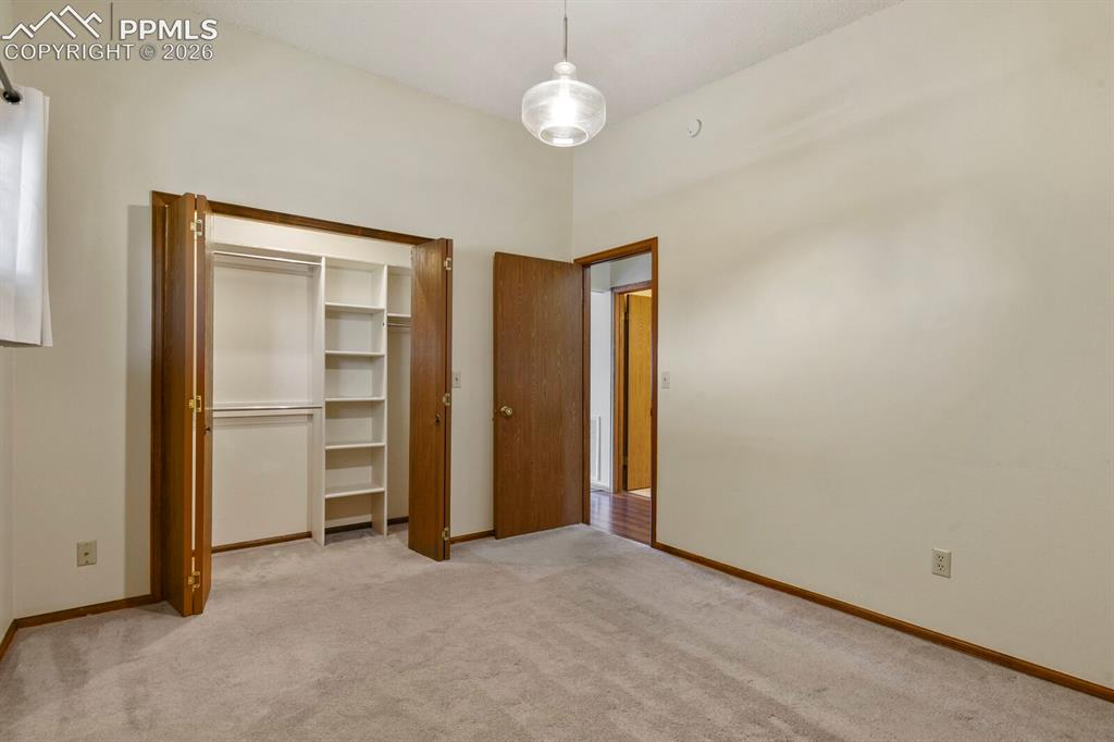 Image 19 of 27: Room featuring light neutral wall paint, light-toned carpeting, and a built