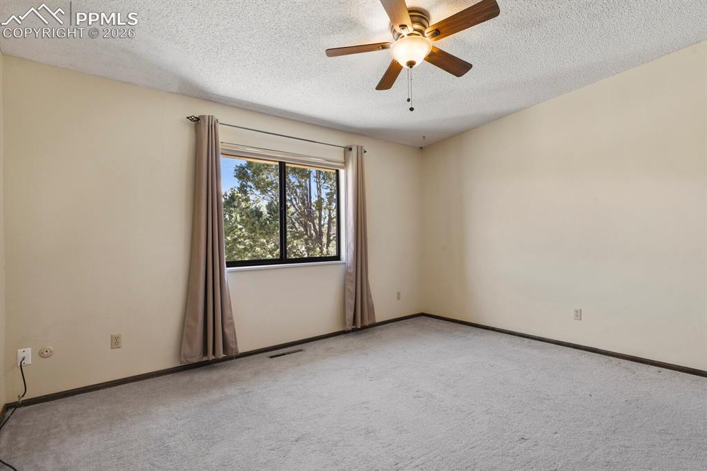 Image 20 of 27: Spacious room featuring a large window with natural light, a wood-finish ce