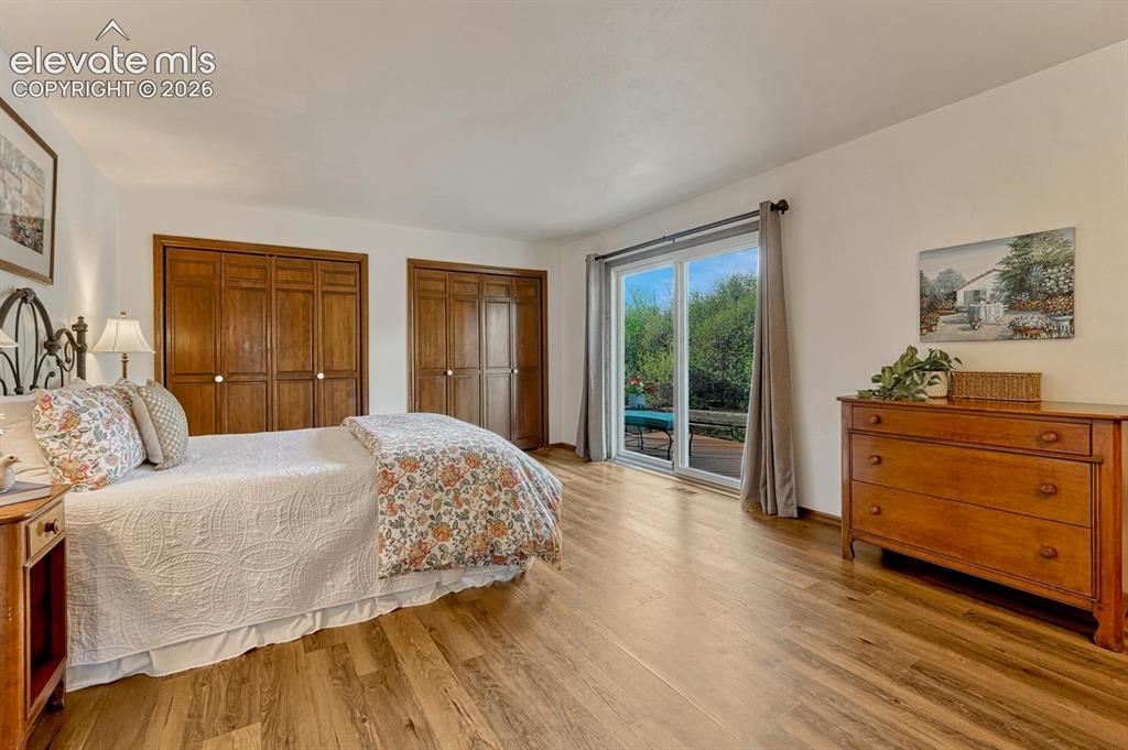 Image 23 of 50: Spacious primary bedroom features walk-out to private deck