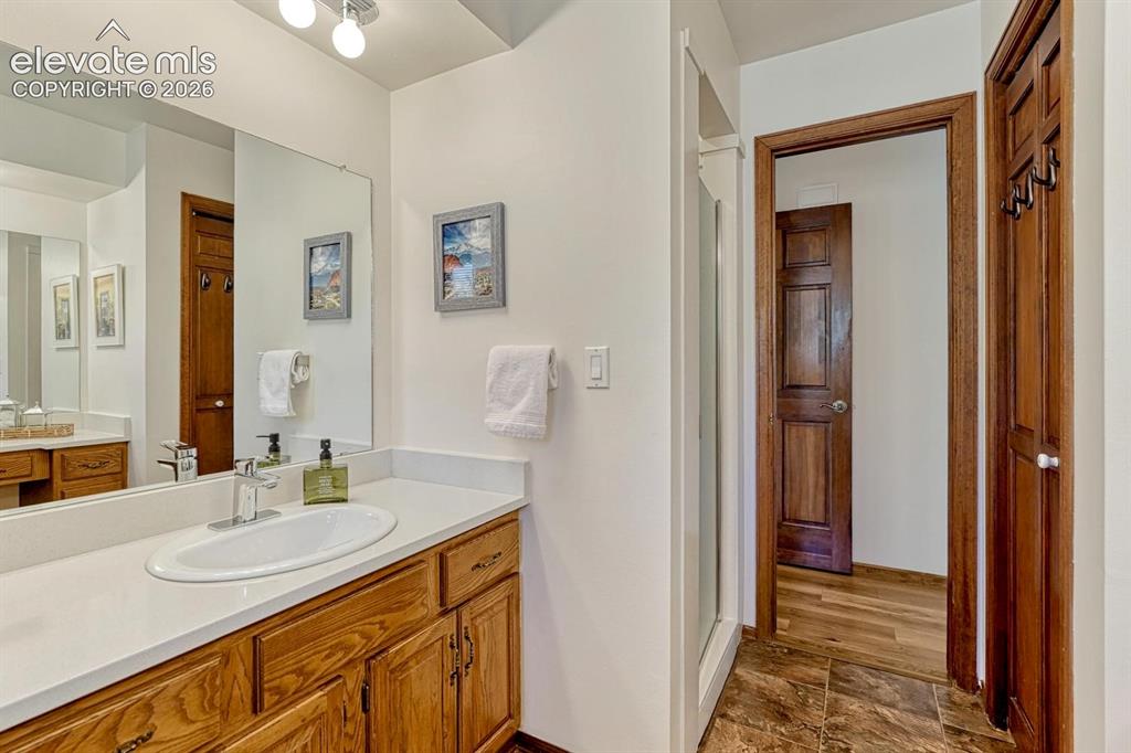 Image 26 of 50: Attached ¾ bathroom has two vanities with quartz counters