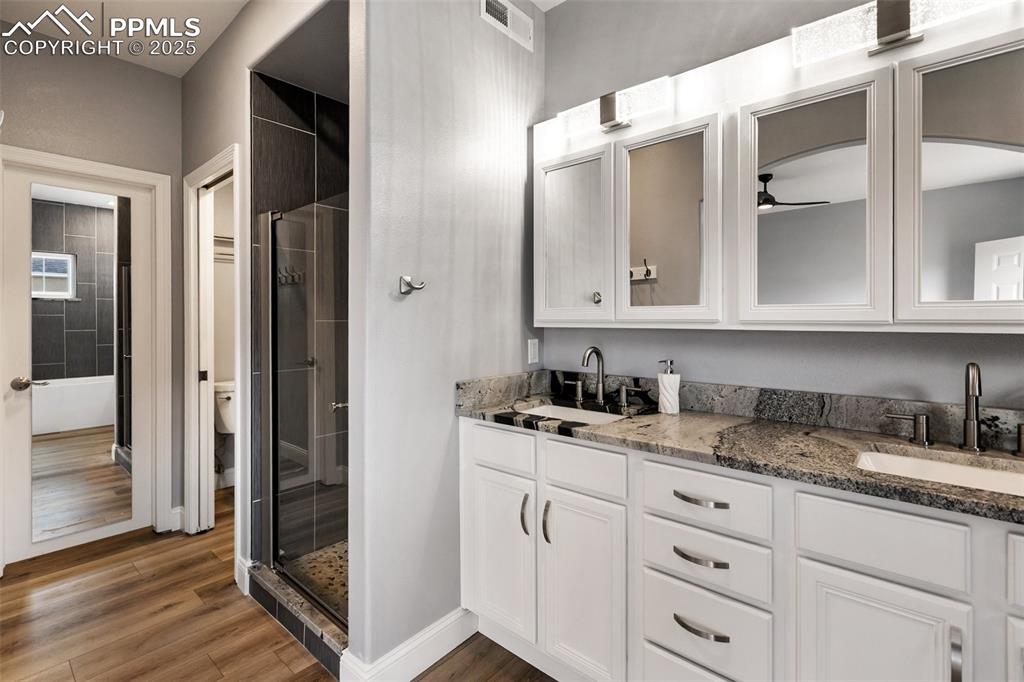 Image 21 of 44: 5-piece primary bath with large walk-in closet main level of upper unit