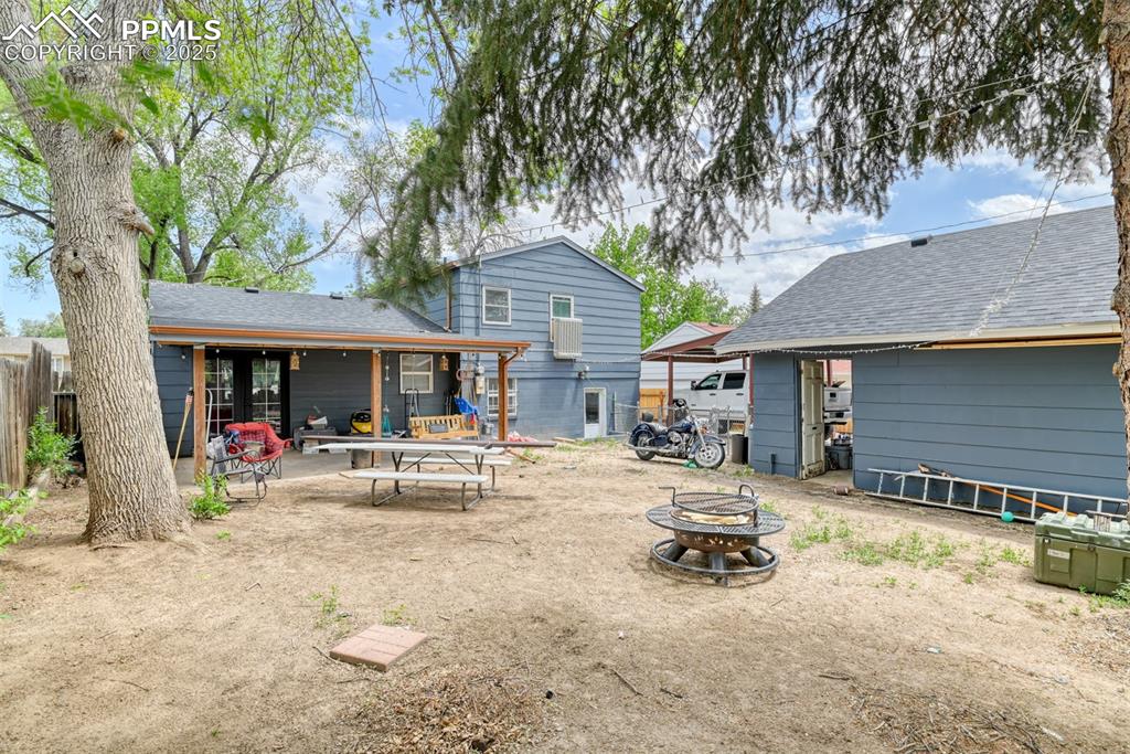 Image 10 of 37: Rear view of house with a fire pit, a shingled roof, and a patio area