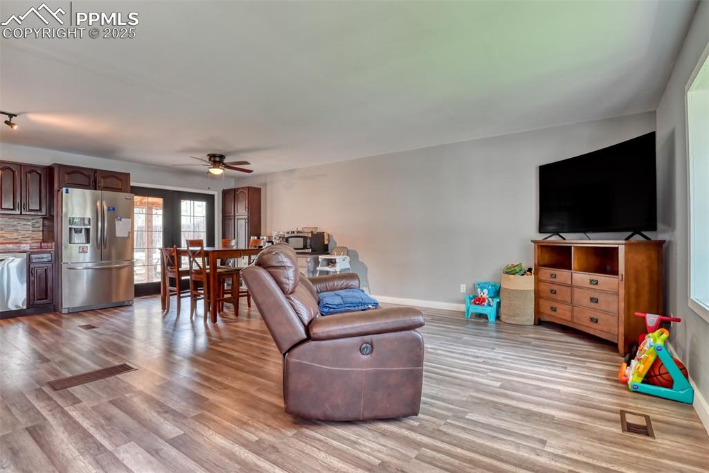 Image 11 of 37: Living area featuring light wood finished floors and ceiling fan