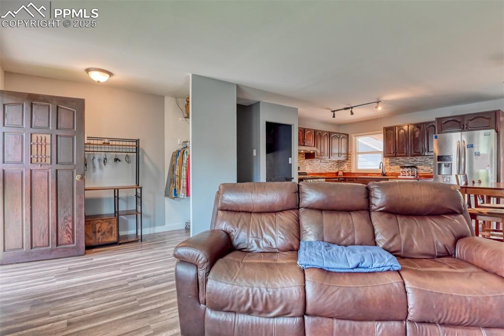 Image 12 of 37: Living room with light wood-style floors and baseboards