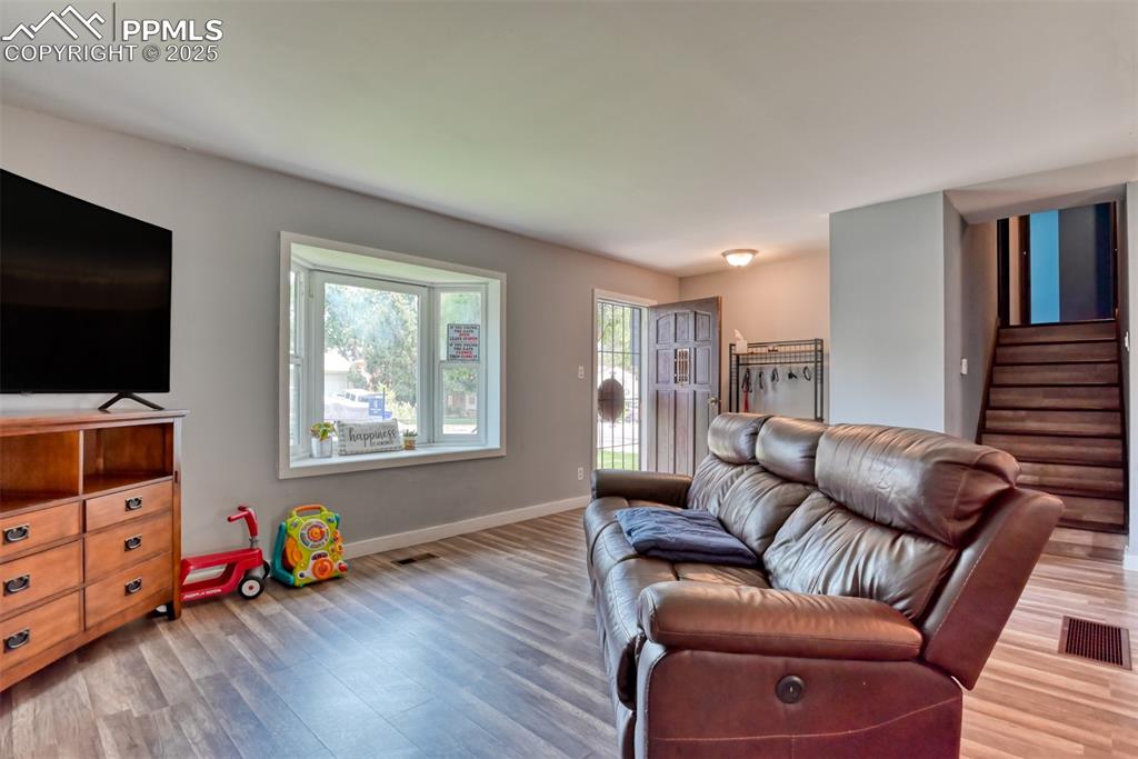 Image 13 of 37: Living room with wood finished floors and stairs
