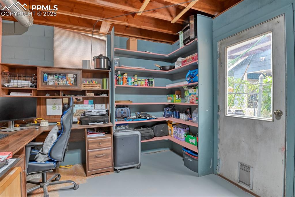 Image 21 of 37: Office space featuring finished concrete floors and concrete block wall