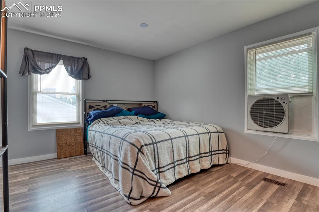 Image 22 of 37: Bedroom featuring multiple windows and wood finished floors