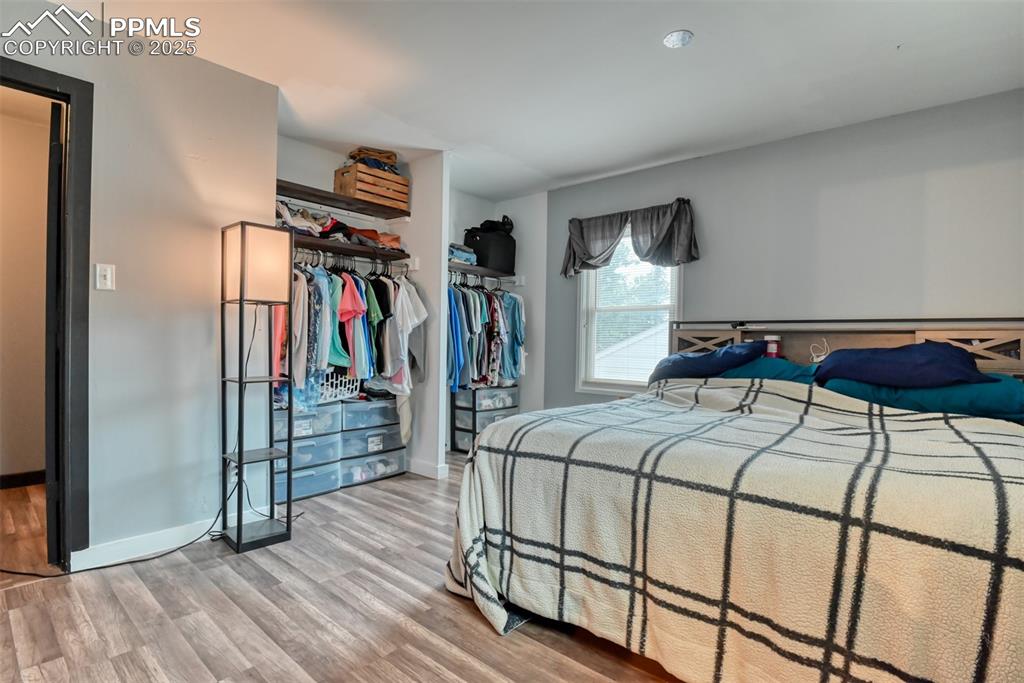 Image 23 of 37: Bedroom with wood finished floors and a closet