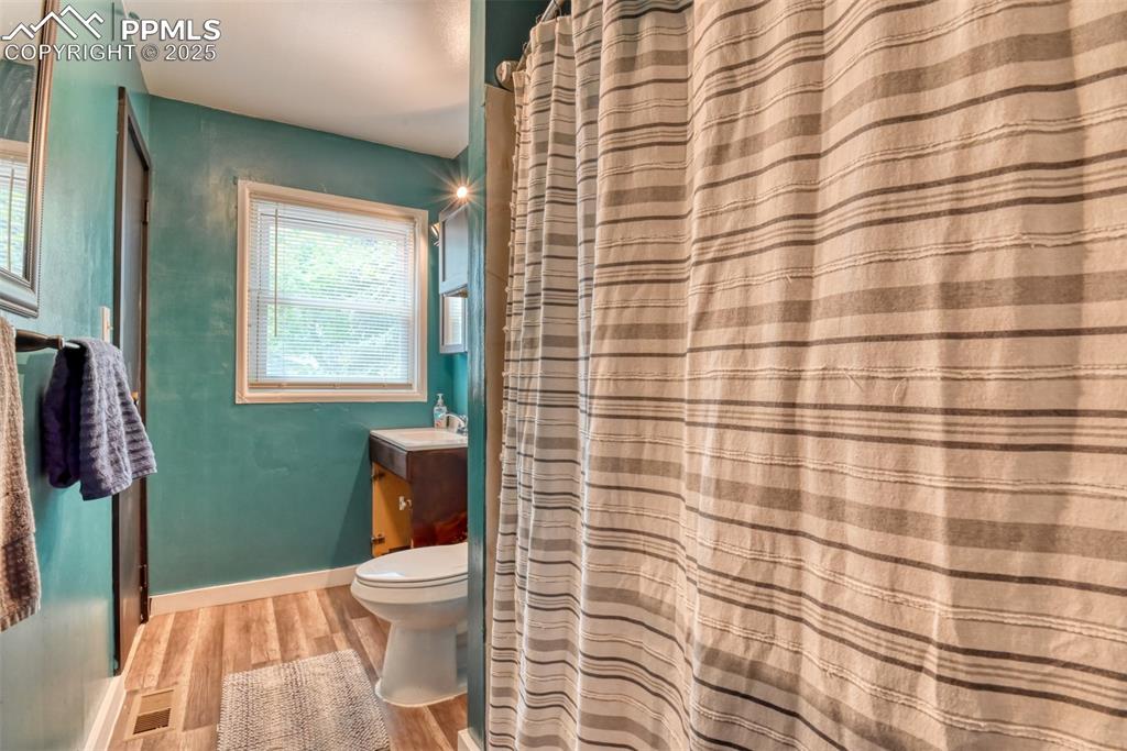 Image 27 of 37: Full bath featuring wood finished floors and vanity