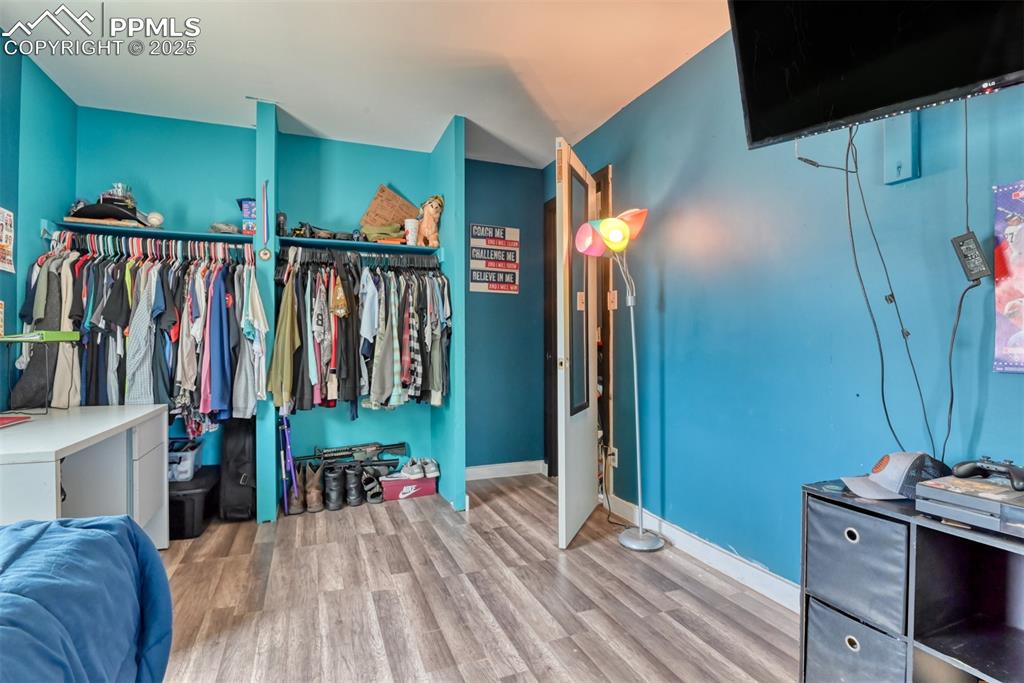 Image 35 of 37: Bedroom with wood finished floors and baseboards