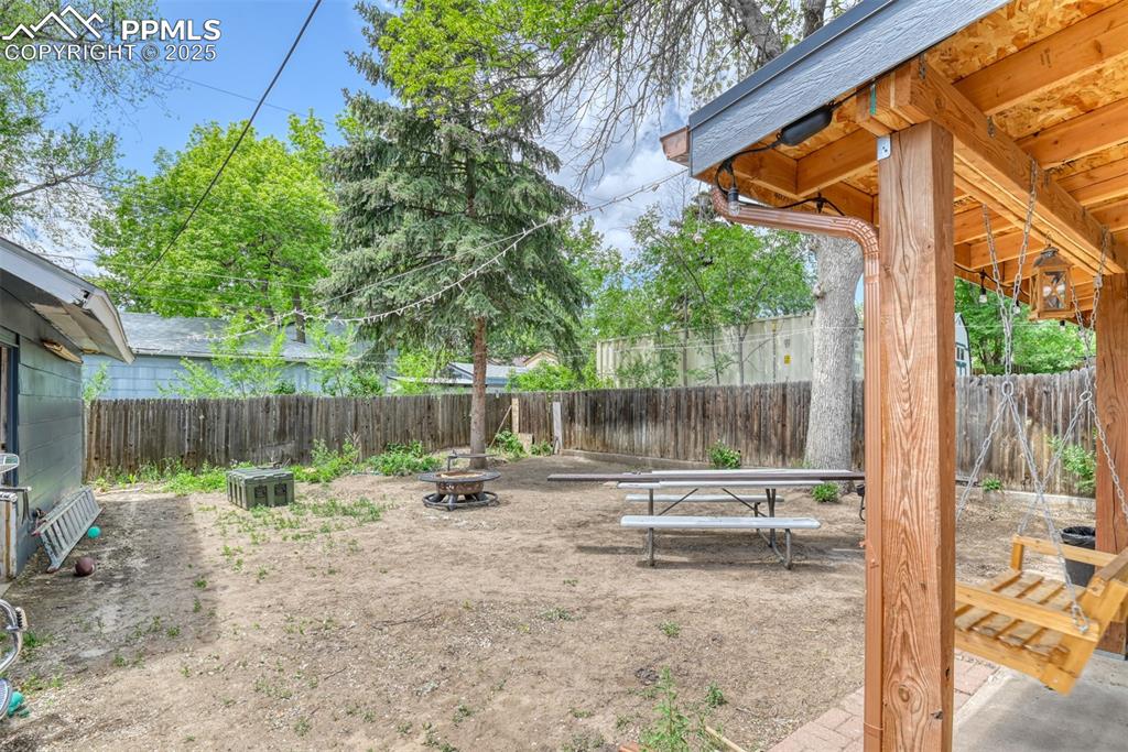 Image 9 of 37: Fenced backyard featuring an outdoor fire pit
