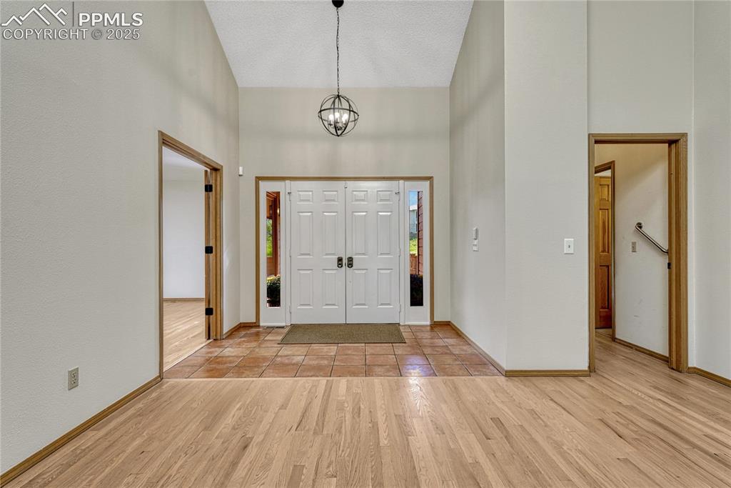 Image 12 of 49: Vaulted Double Door Tiled Entry, Opens to Hardwood Floors