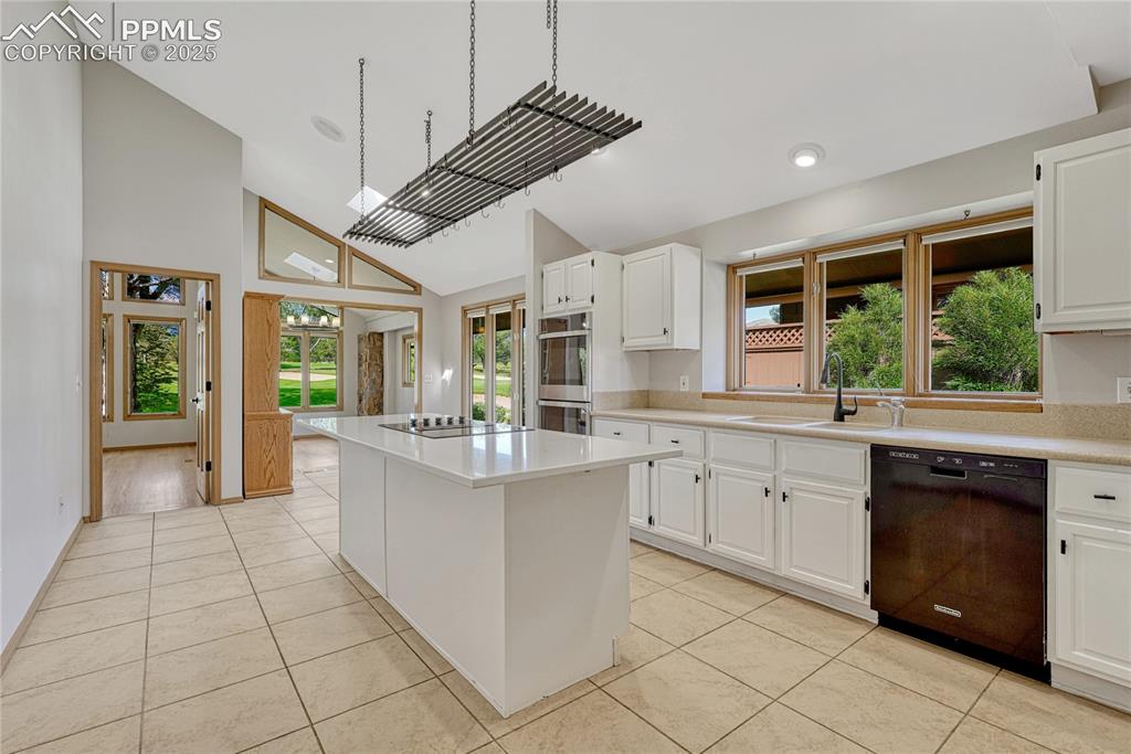 Image 14 of 49: Vaulted Tiled Island Kitchen with Skylight