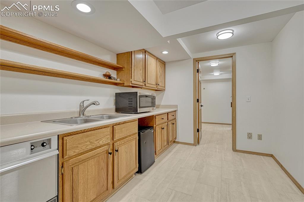 Image 25 of 49: Lower Level Tiled Mini-Kitchen / Bar area with Ice Maker