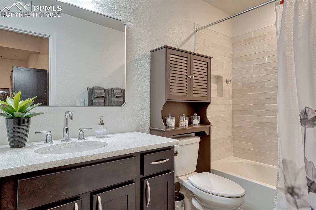 Image 39 of 50: The basement level full bathroom has the same sparkling white counters and