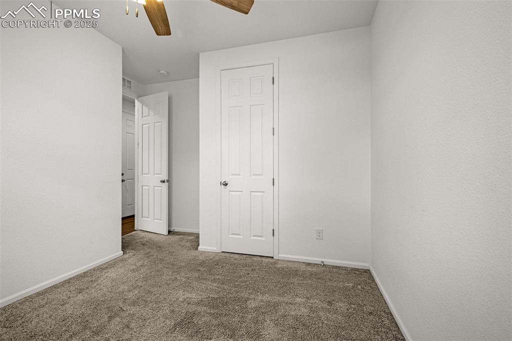 Image 10 of 37: Unfurnished bedroom with dark colored carpet and ceiling fan