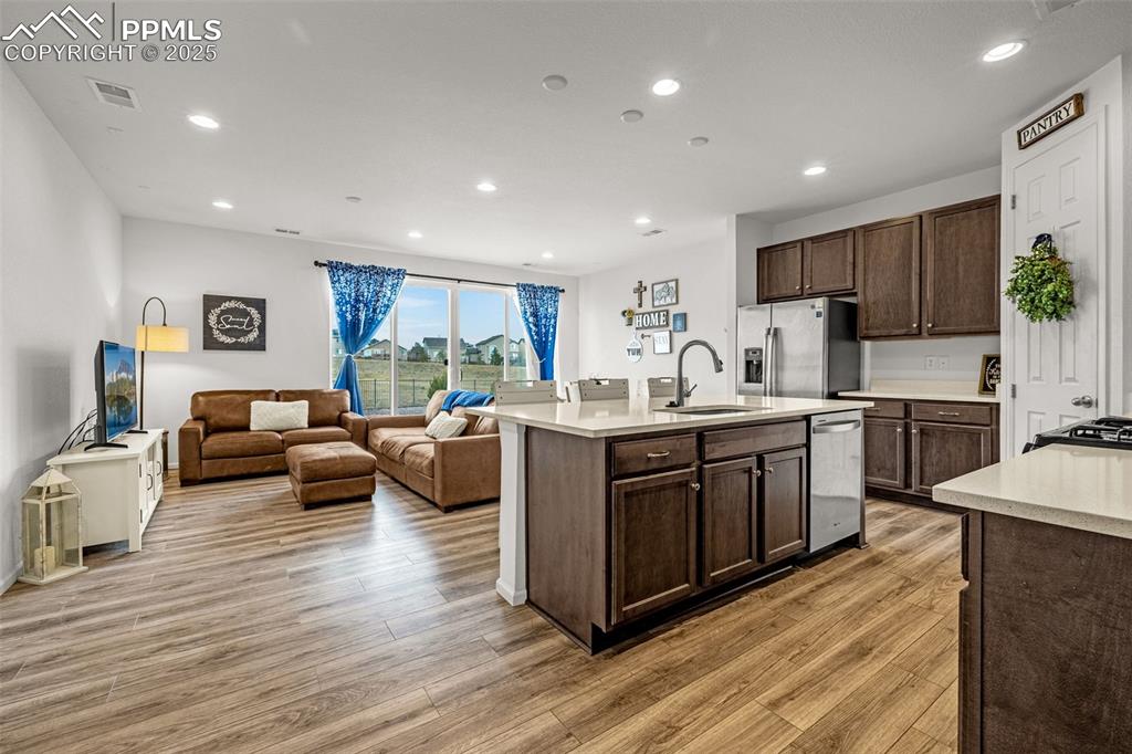 Image 11 of 37: Kitchen featuring recessed lighting, open floor plan, dark brown cabinets, 