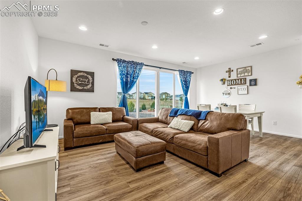 Image 16 of 37: Living area with recessed lighting and light wood finished floors
