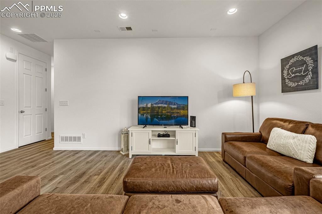 Image 20 of 37: Living room with recessed lighting and wood finished floors