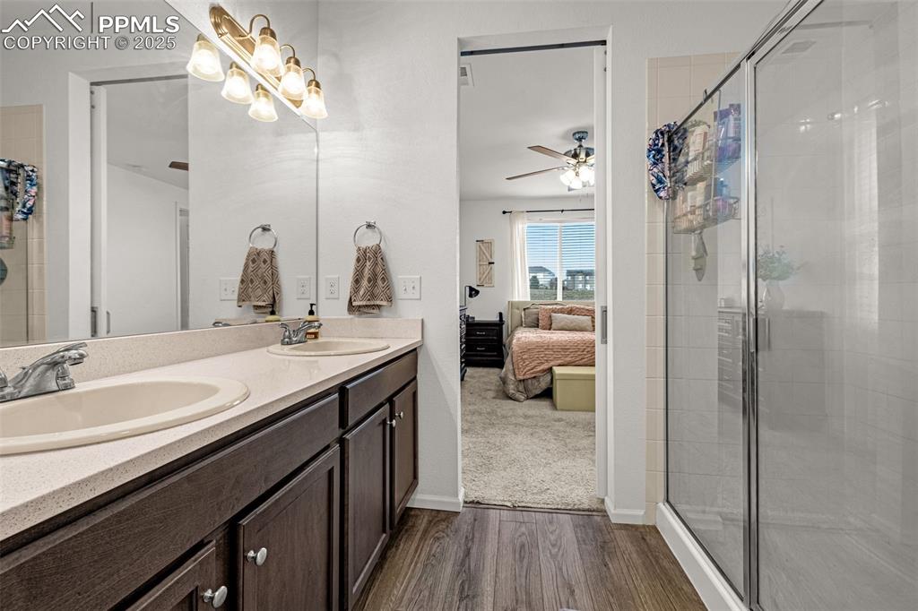 Image 26 of 37: Full bathroom with connected bathroom, a stall shower, double vanity, dark 